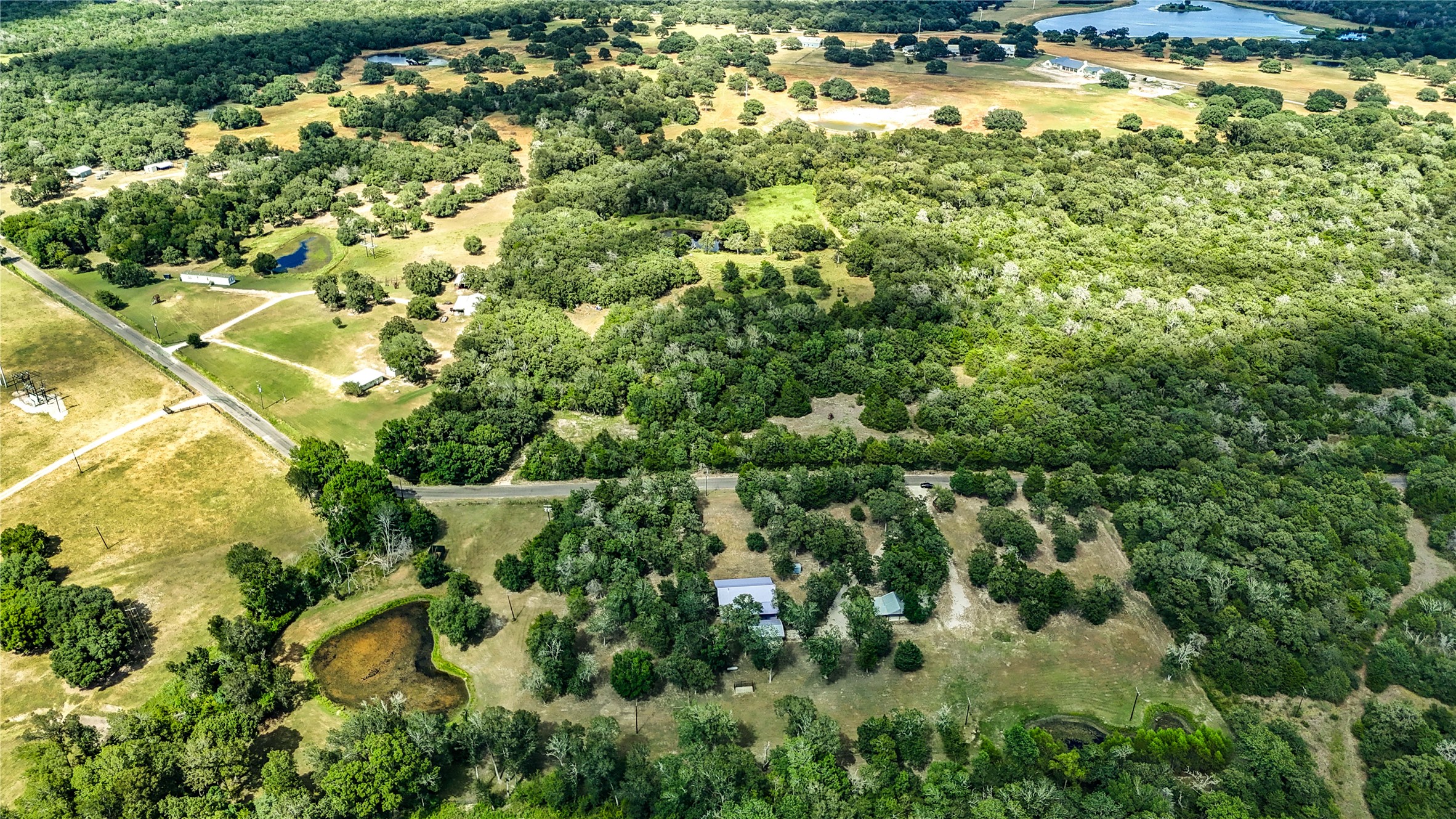 8805 Sun Oil Road Brenham, TX 77833 - Photo 44 of 50 Expansive rural property surrounded by lush greenery, offering privacy and serene natural landscapes with small ponds and spacious open fields.