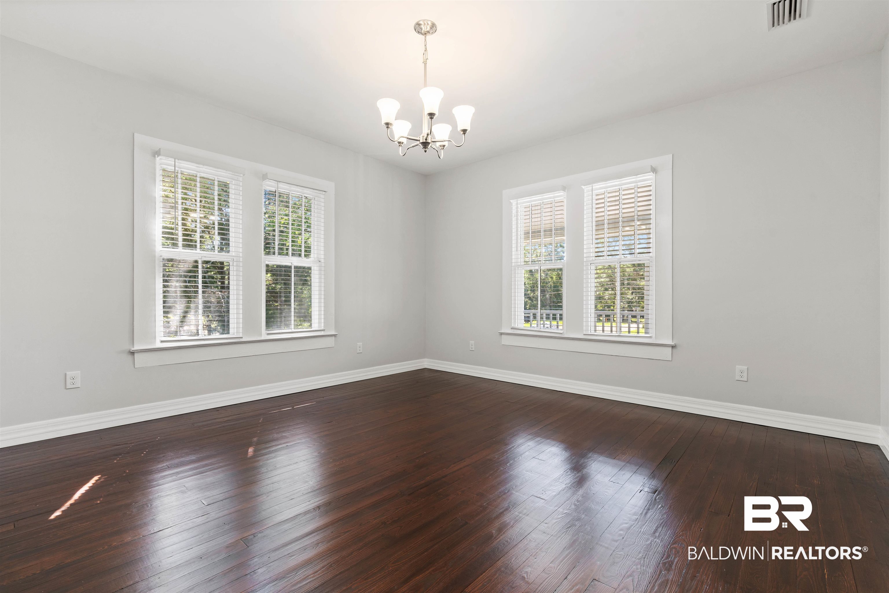 407 East 2nd Street Bay Minette, AL 36507 - Photo 28 of 40 Empty room featuring dark wood-type flooring and a chandelier