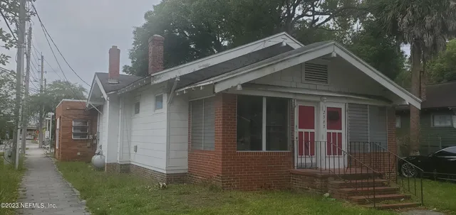 a view of a house with brick walls and a yard
