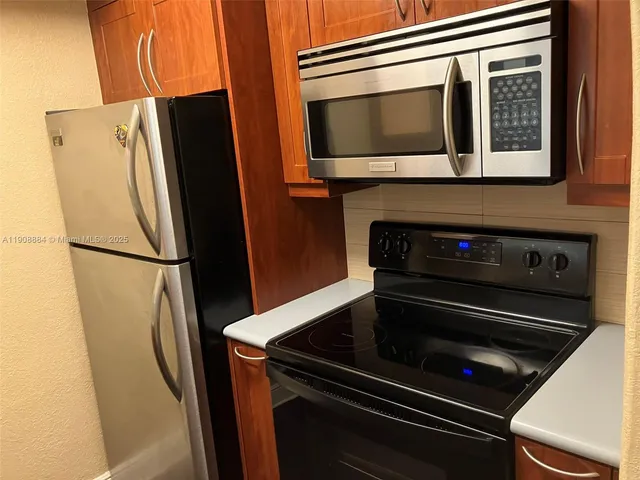 a metallic refrigerator freezer sitting in a kitchen