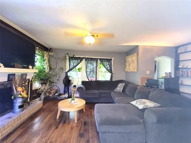 a living room with furniture a fireplace and a dining table with wooden floor