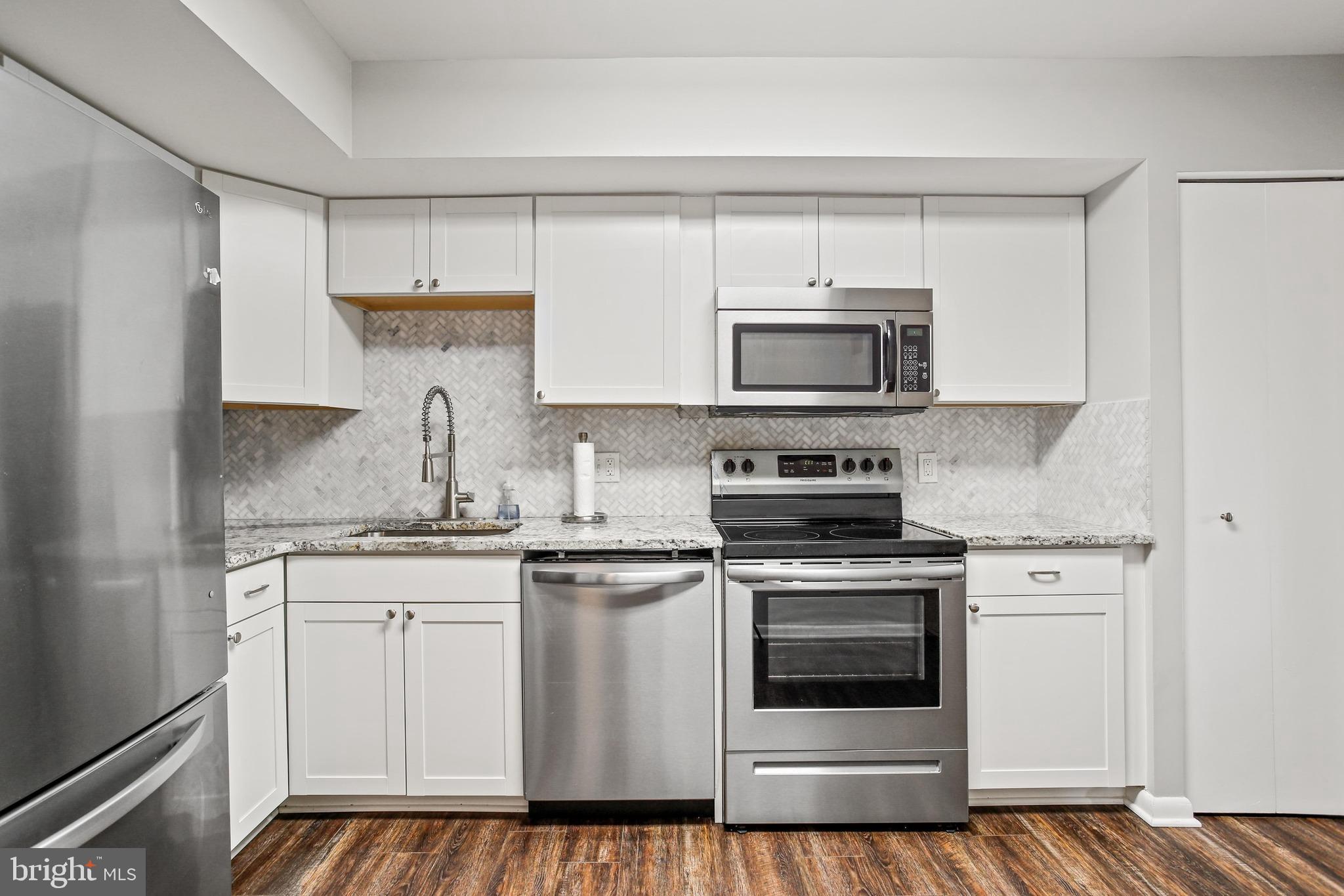 4 Candlemaker Court, Unit 301 Baltimore, MD 21208 - Photo 3 of 32 a kitchen with stainless steel appliances granite countertop a stove a sink and a microwave