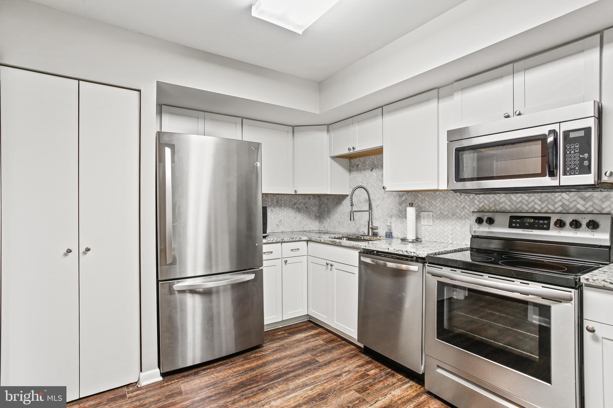 4 Candlemaker Court, Unit 301 Baltimore, MD 21208 - Photo 4 of 32 a kitchen with stainless steel appliances a refrigerator stove and microwave