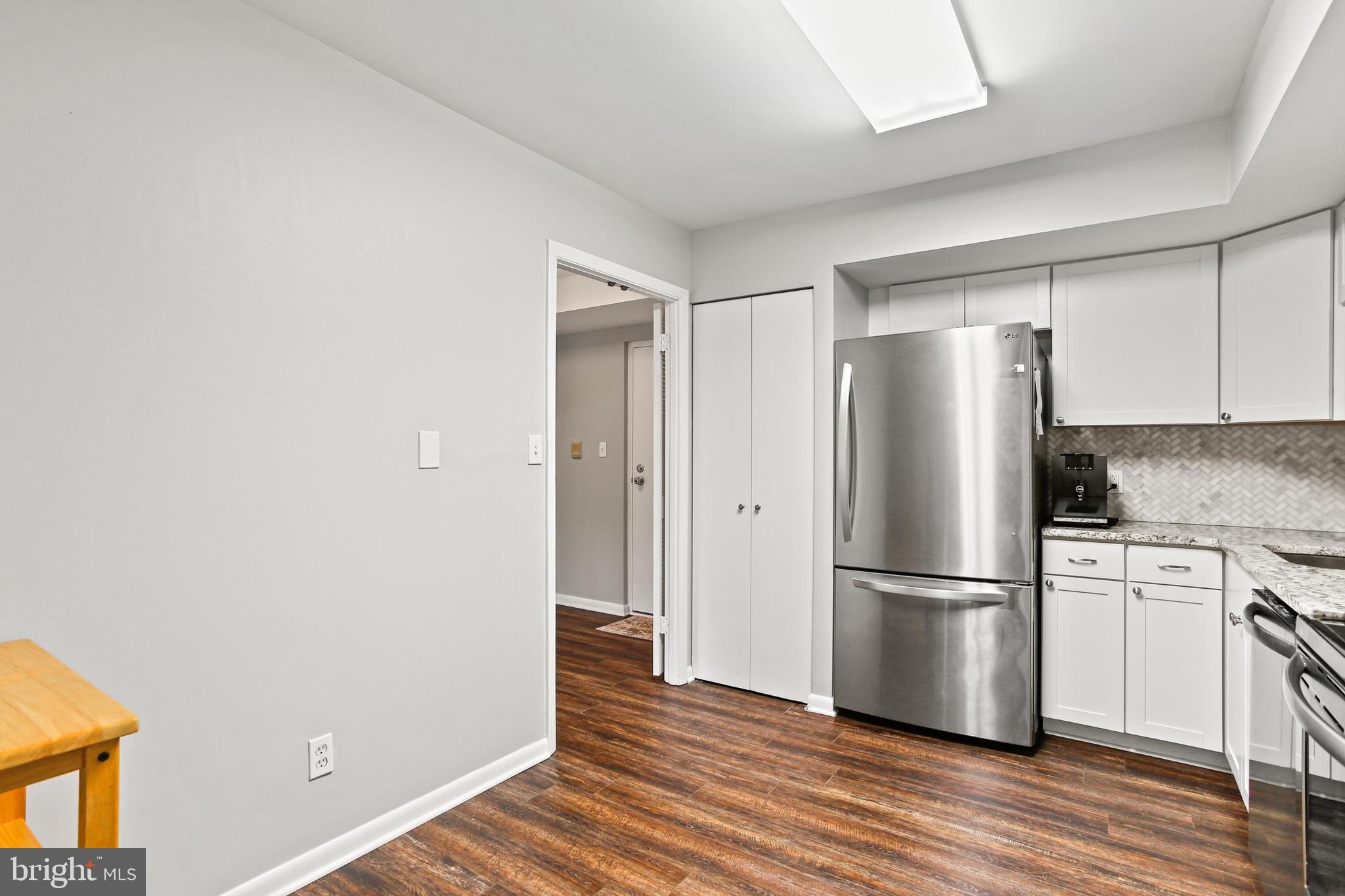 4 Candlemaker Court, Unit 301 Baltimore, MD 21208 - Photo 6 of 32 a kitchen with wooden floors white cabinets and stainless steel appliances