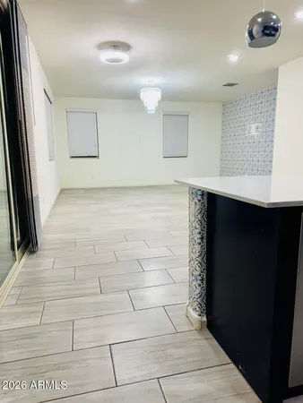 a view of hallway with a window and chandelier