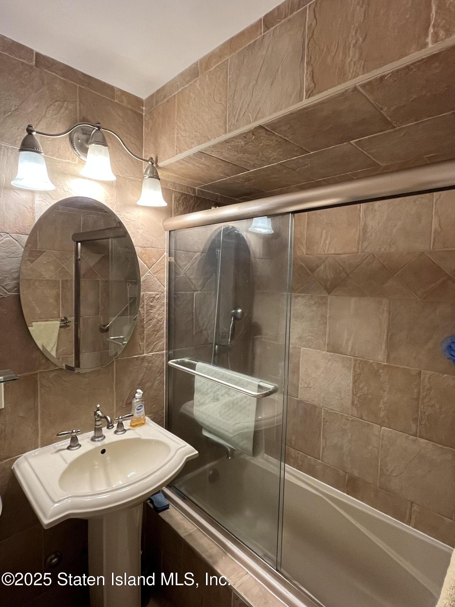 1100 Clove Road, Unit 2N Staten Island, NY 10301 - Photo 13 of 27 a bathroom with a sink and a mirror