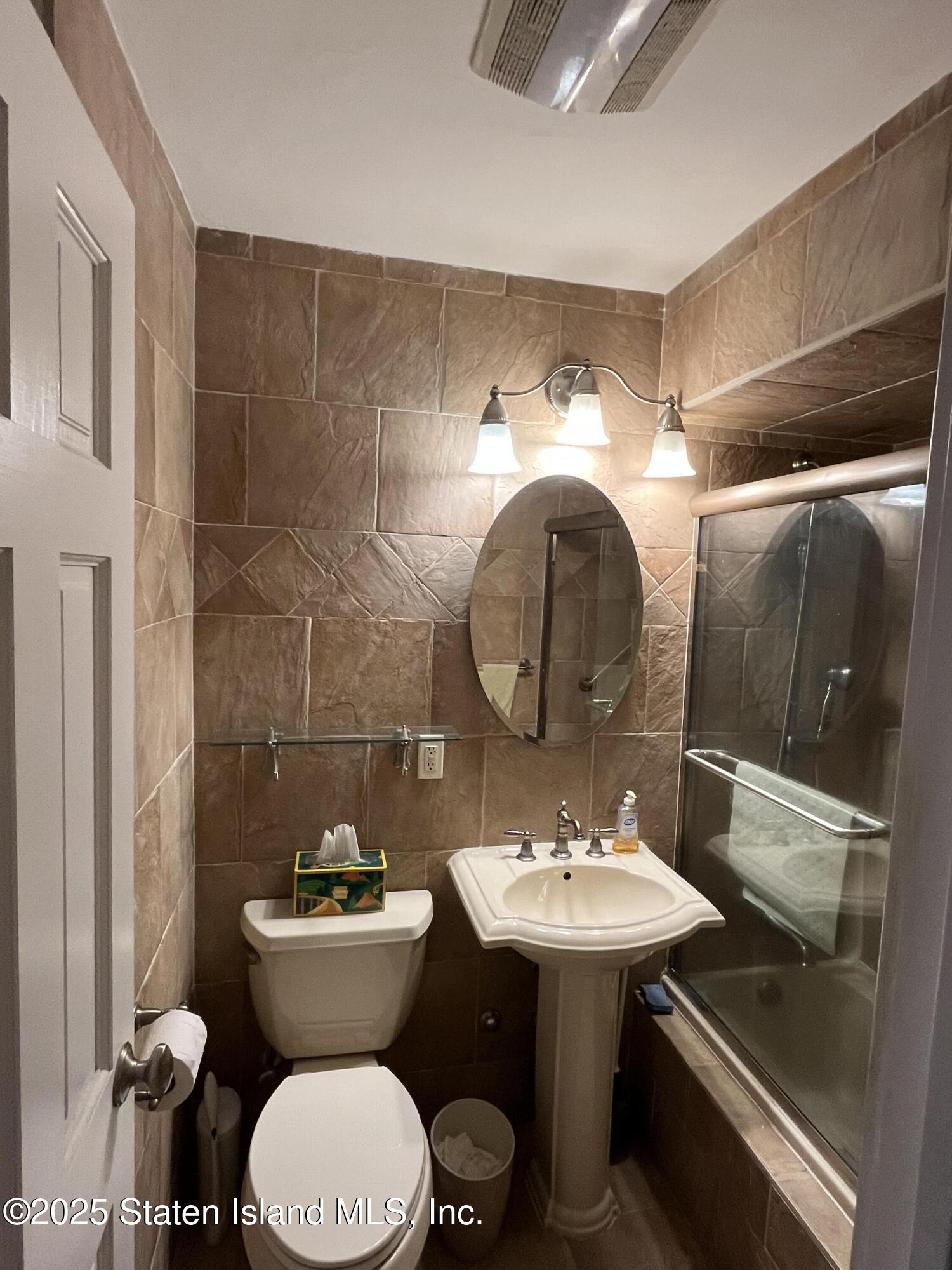 1100 Clove Road, Unit 2N Staten Island, NY 10301 - Photo 14 of 27 a bathroom with a sink toilet and a mirror