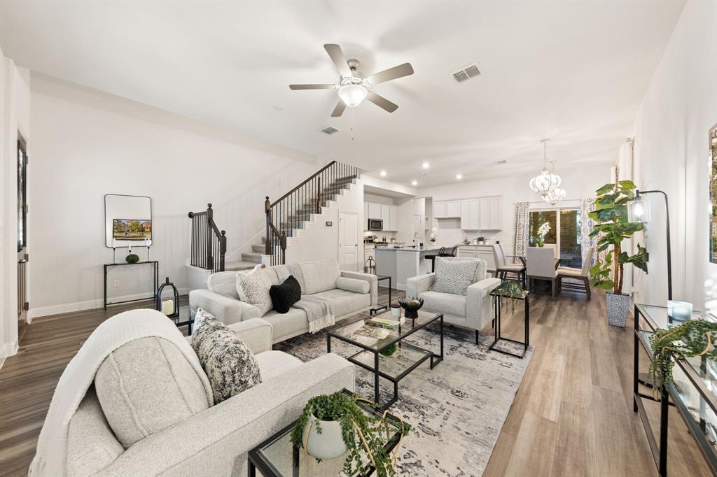a living room with furniture kitchen view and a chandelier