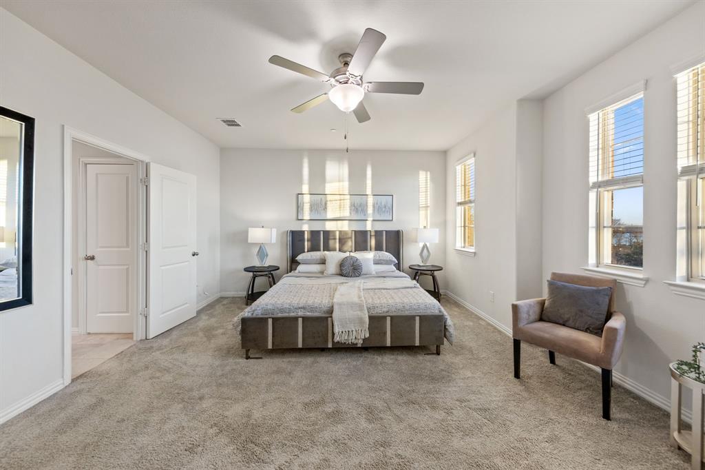 7505 Sunset Boulevard Rowlett, TX 75088 - Photo 13 of 33 a spacious bedroom with a bed a couch and a large window