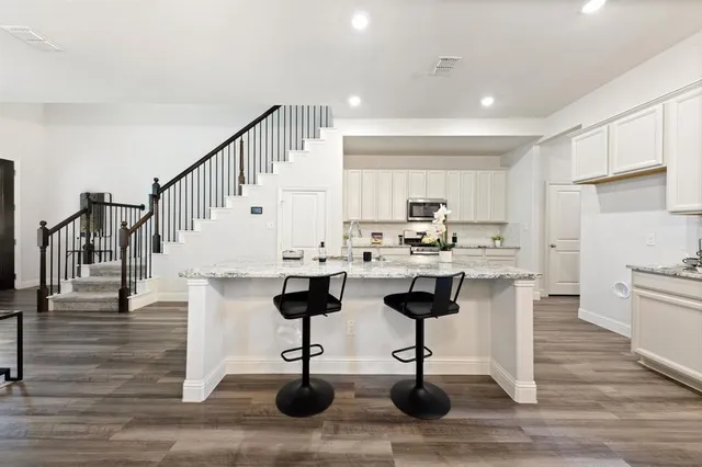 a kitchen with stainless steel appliances kitchen island granite countertop a stove a sink and a refrigerator