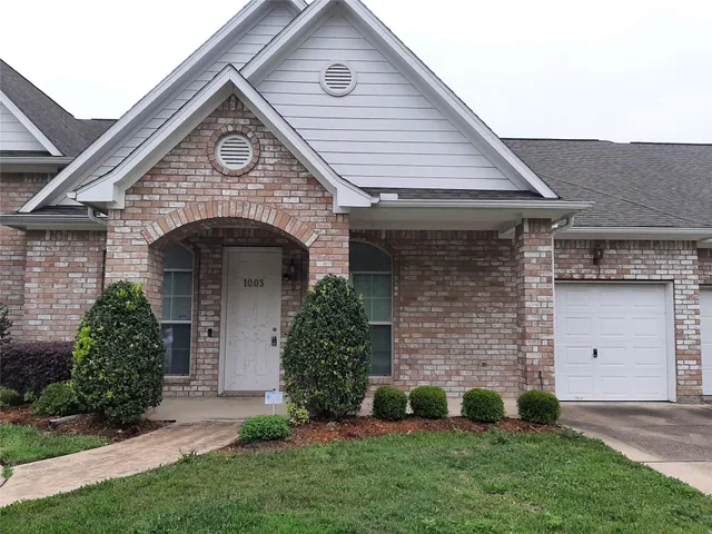 a front view of a house with a garden and plants