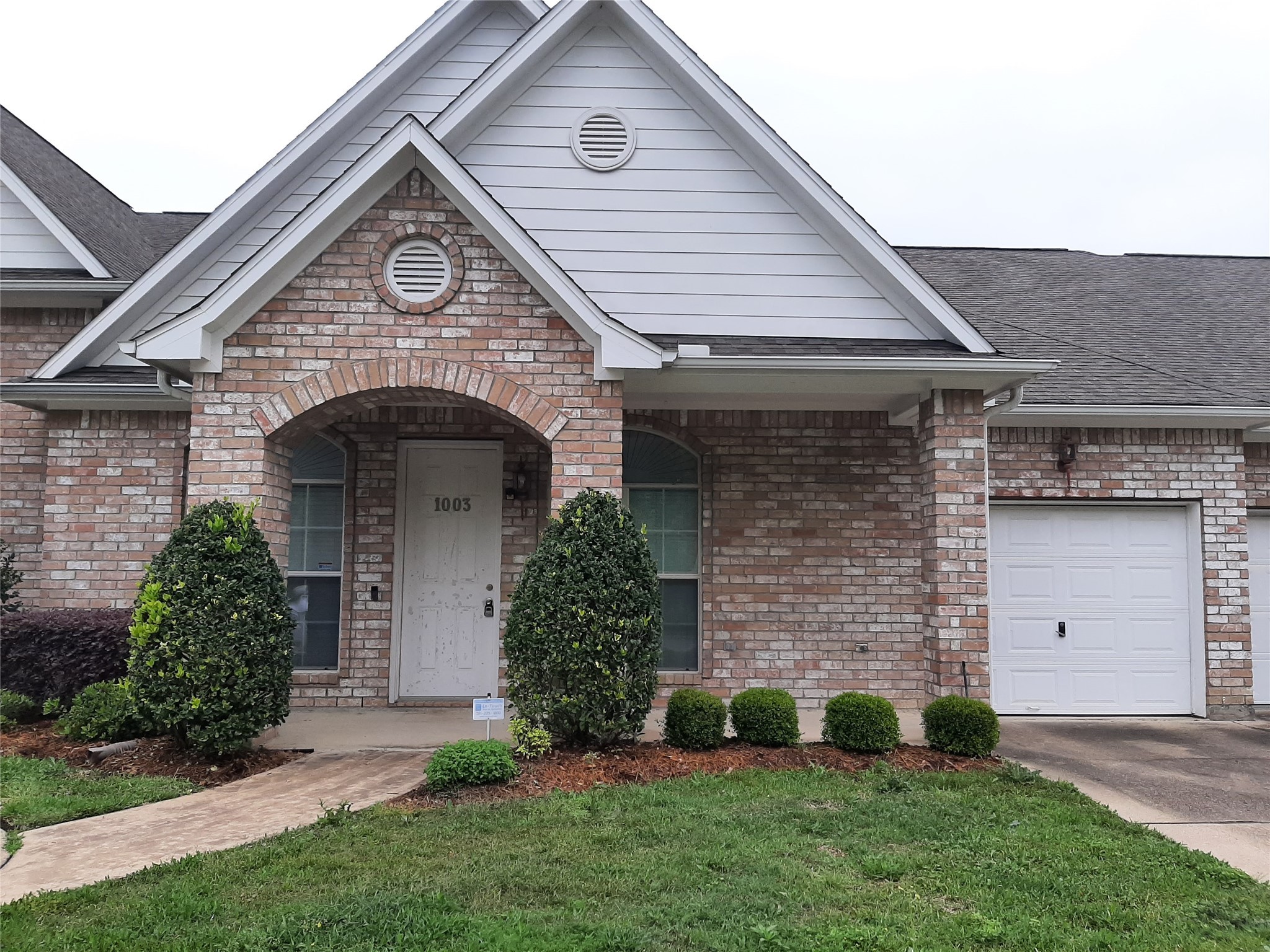 a front view of a house with a garden and plants
