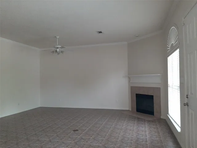a view of an empty room with a fireplace and a window