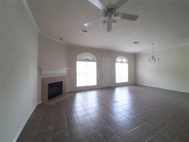 an empty room with windows and fireplace