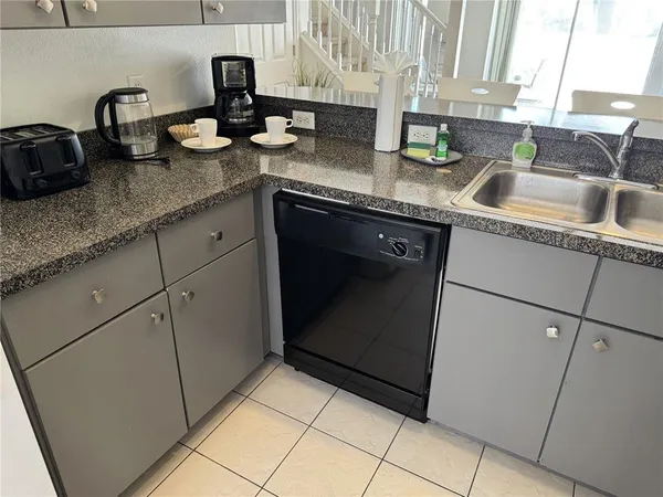 a kitchen with a sink a stove top oven and cabinets