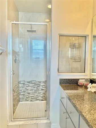 a bathroom with a granite countertop shower and a sink
