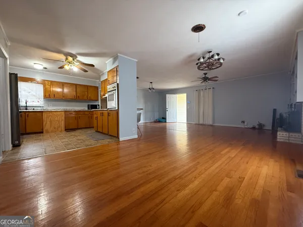 a view of a kitchen with a fridge and wooden floor