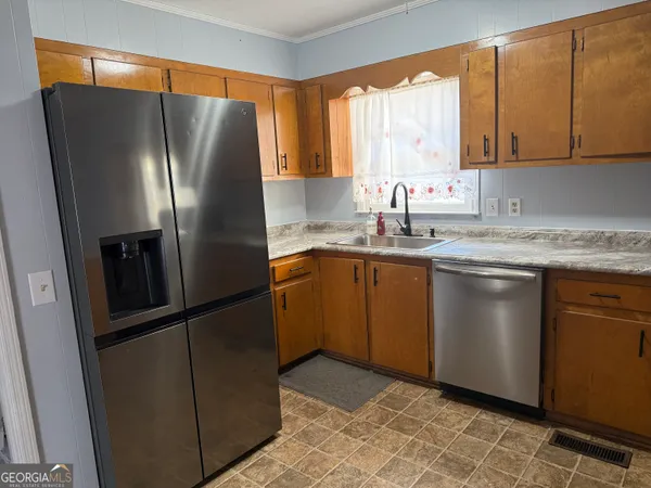 a kitchen with stainless steel appliances granite countertop a refrigerator a sink a stove and cabinets