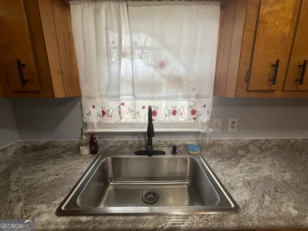 a kitchen with a sink and a granite counter top