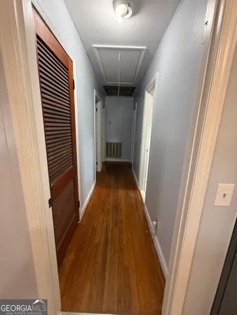 a view of a hallway with wooden floor and staircase