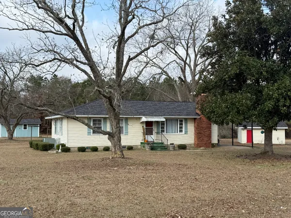 a front view of a house with a tree