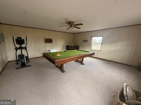 a room with pool table and windows