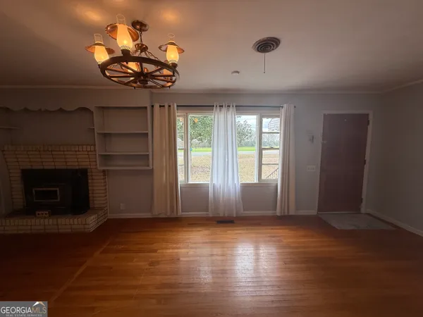 a view of a livingroom with a fireplace and window