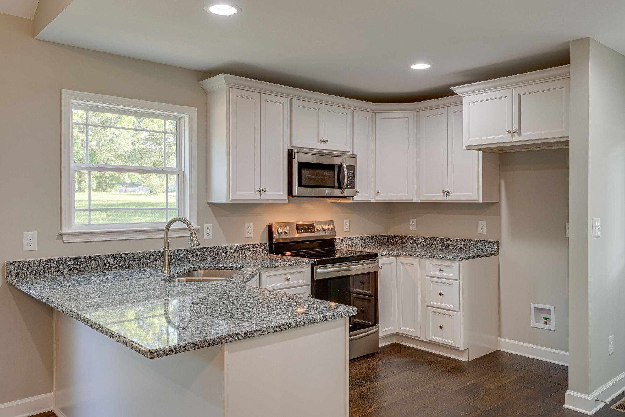 400 Kaiser Road Dickson, TN 37055 - Photo 5 of 11 a kitchen with granite countertop a sink white cabinets and a stove