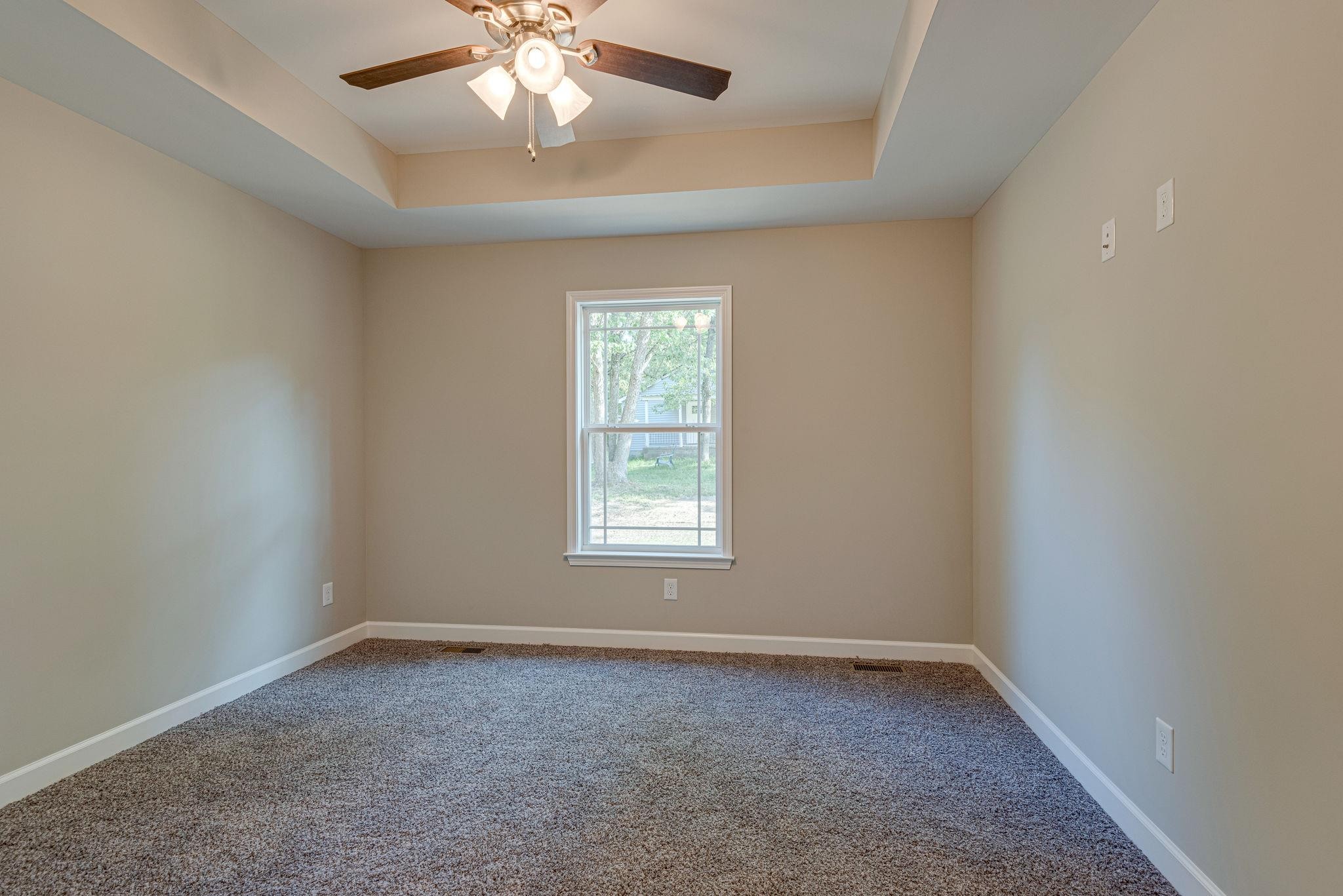 400 Kaiser Road Dickson, TN 37055 - Photo 8 of 11 an empty room with a chandelier fan and windows