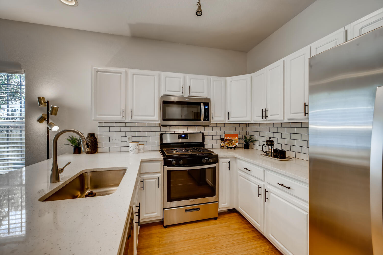 1206 Maple Avenue Austin, TX 78702 - Photo 30 of 39 a kitchen with white cabinets and stainless steel appliances