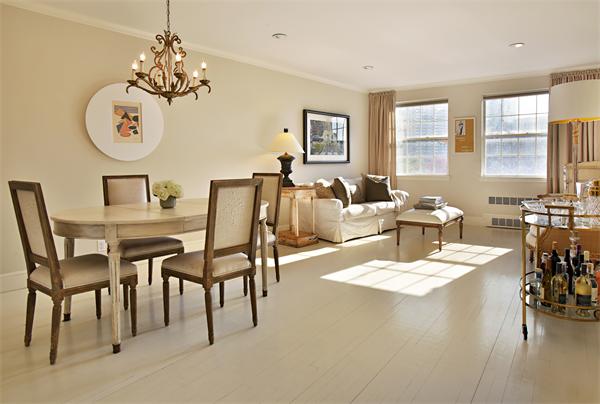 a dining room with wooden floor a chandelier a wooden table and chairs