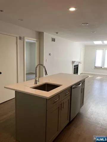 a view of a sink and dishwasher with wooden floor