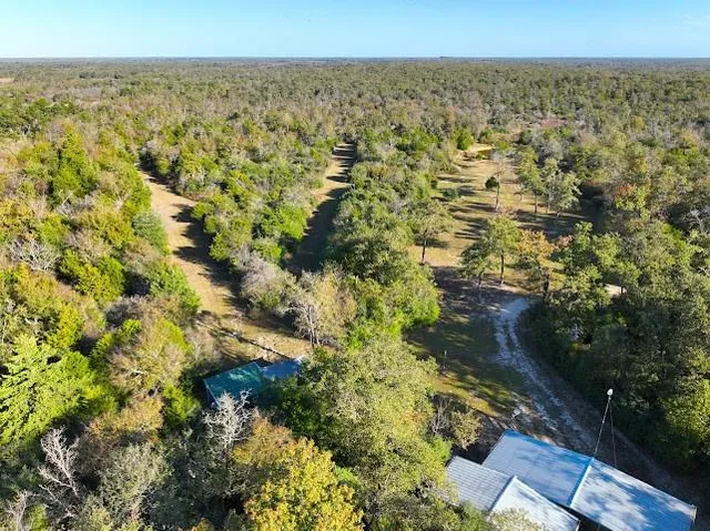 an aerial view of a house having yard and swimming pool