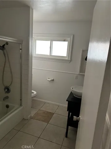 a bathroom with a granite countertop sink a toilet and shower
