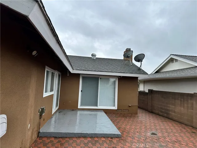 a backyard of a house with wooden floor and brick wall