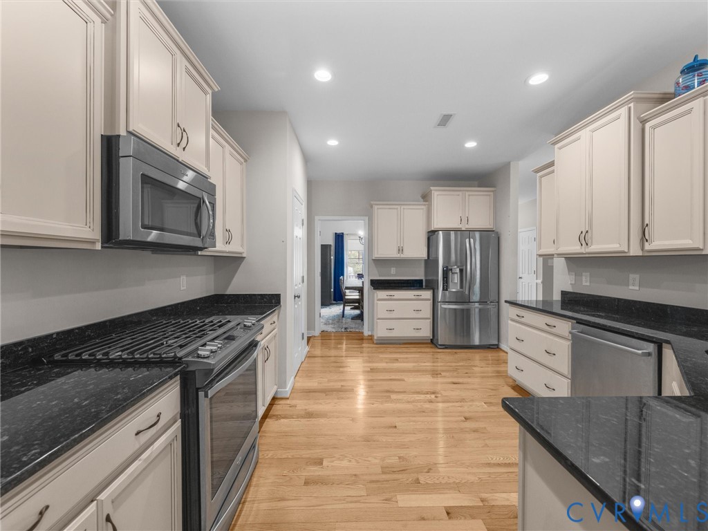 10824 Avening Road Chesterfield, VA 23832 - Photo 14 of 47 a kitchen with stainless steel appliances granite countertop a stove top oven a sink and dishwasher a oven with wooden cabinets