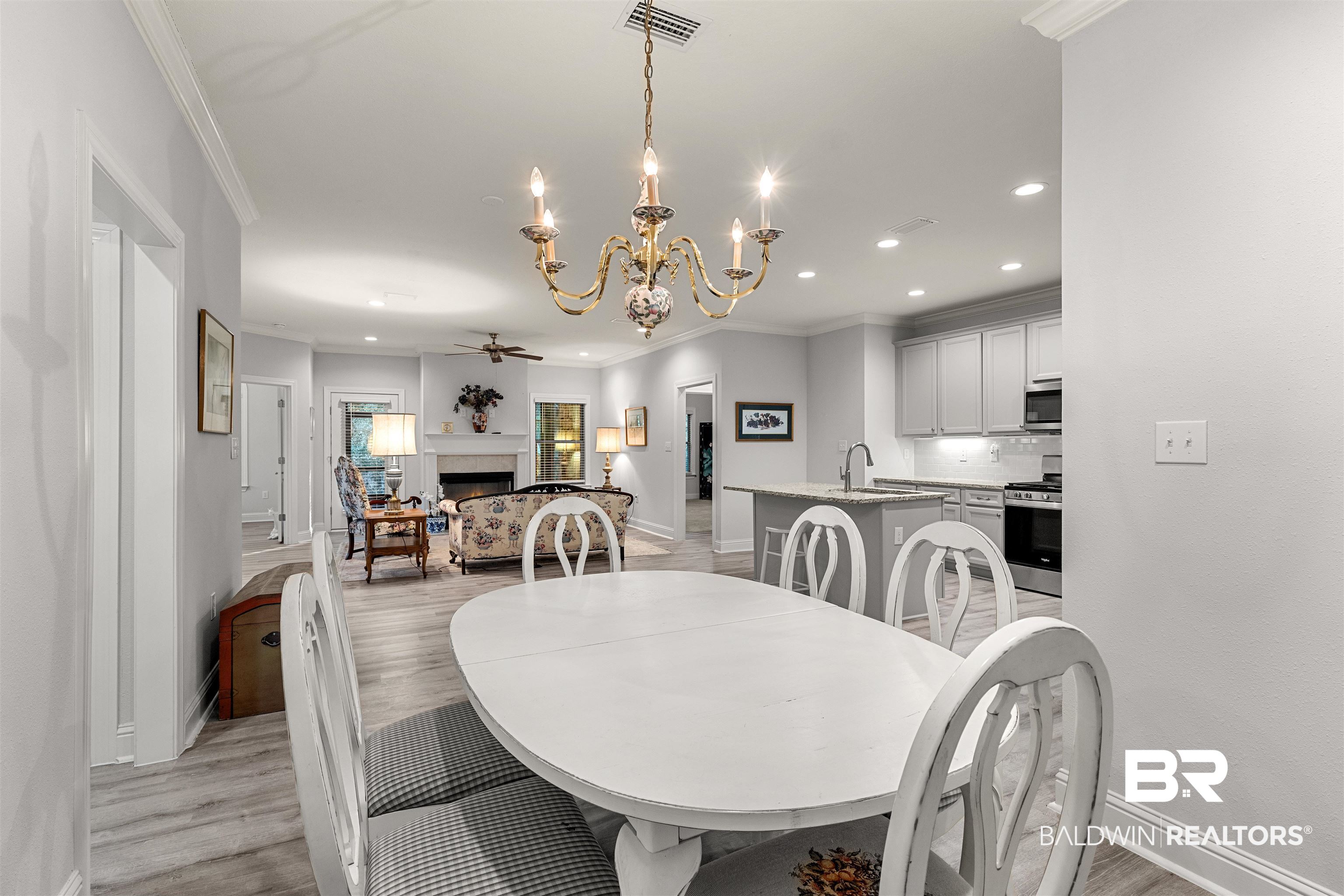 702 Holmes Avenue, Unit 702 Foley, AL 36535 - Photo 12 of 33 Dining area featuring ceiling fan with notable chandelier, crown molding, light hardwood / wood-style flooring, and sink