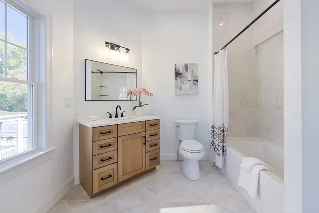a bathroom with a double vanity sink toilet mirror and shower