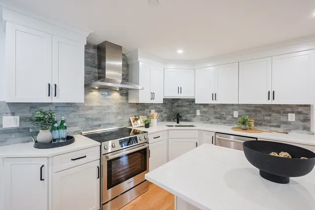 a kitchen with white cabinets and white appliances