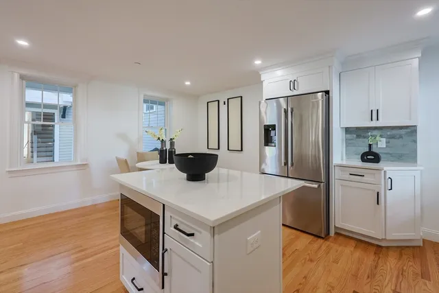 a kitchen with stainless steel appliances granite countertop a refrigerator a stove and a wooden floors