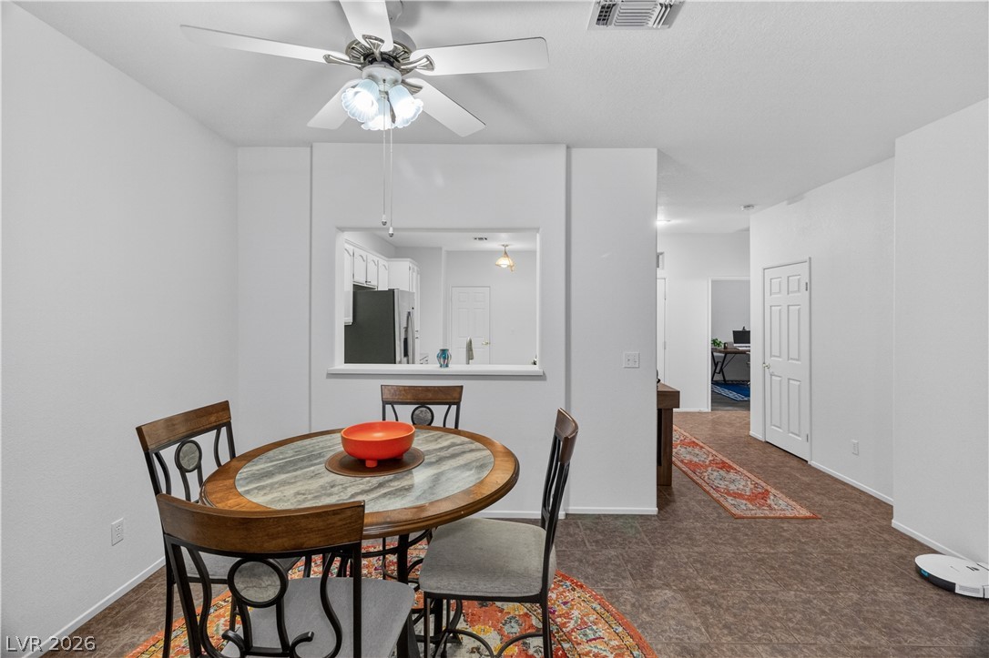 3376 Partridge Run Street Laughlin, NV 89029 - Photo 17 of 92 A casual dining space features a ceiling fan, seamlessly connecting to an open kitchen pass-through.