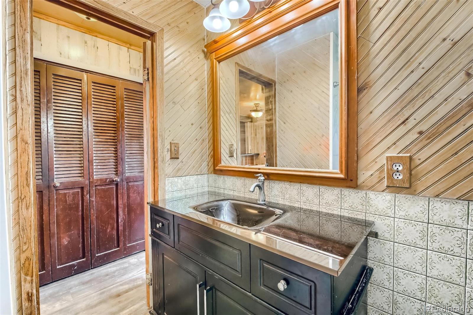 145 Bailey Drive Bailey, CO 80421 - Photo 13 of 40 a bathroom with a sink a mirror and next to a window