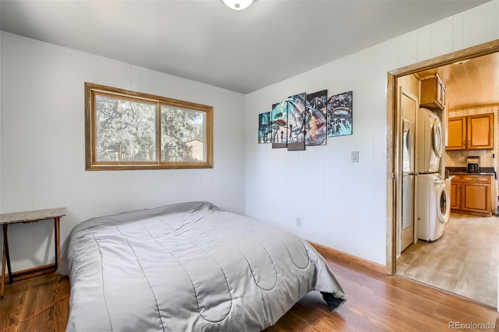 145 Bailey Drive Bailey, CO 80421 - Photo 14 of 40 a bedroom with a bed and a painting on the wall