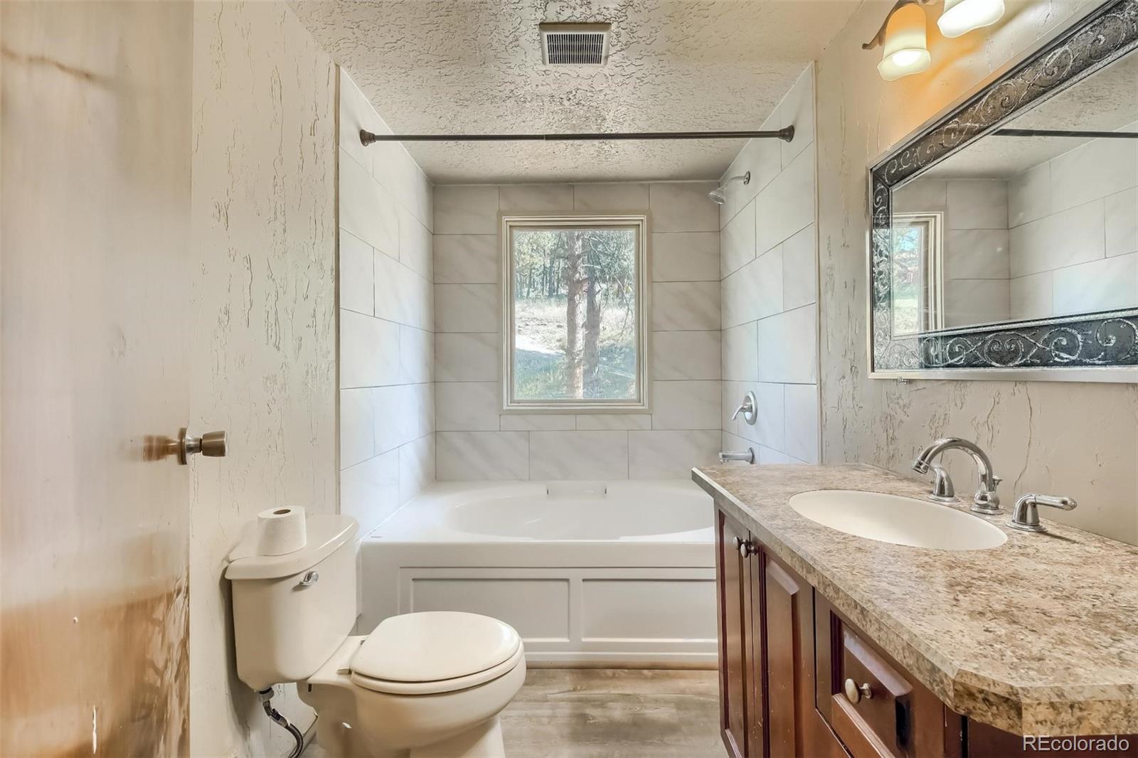 145 Bailey Drive Bailey, CO 80421 - Photo 16 of 40 a bathroom with a granite countertop sink toilet and shower