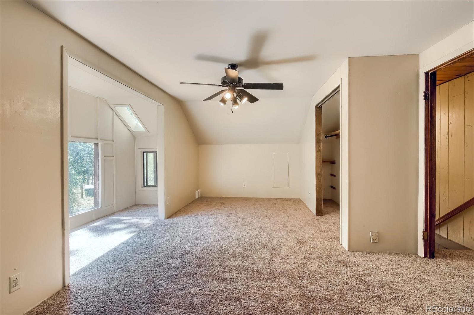 145 Bailey Drive Bailey, CO 80421 - Photo 18 of 40 an empty room with chandelier fan and windows