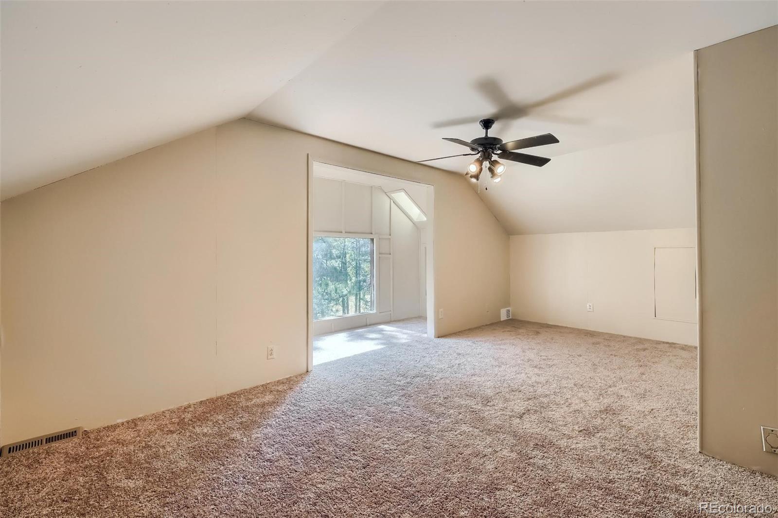 145 Bailey Drive Bailey, CO 80421 - Photo 19 of 40 an empty room with a ceiling fan and a window