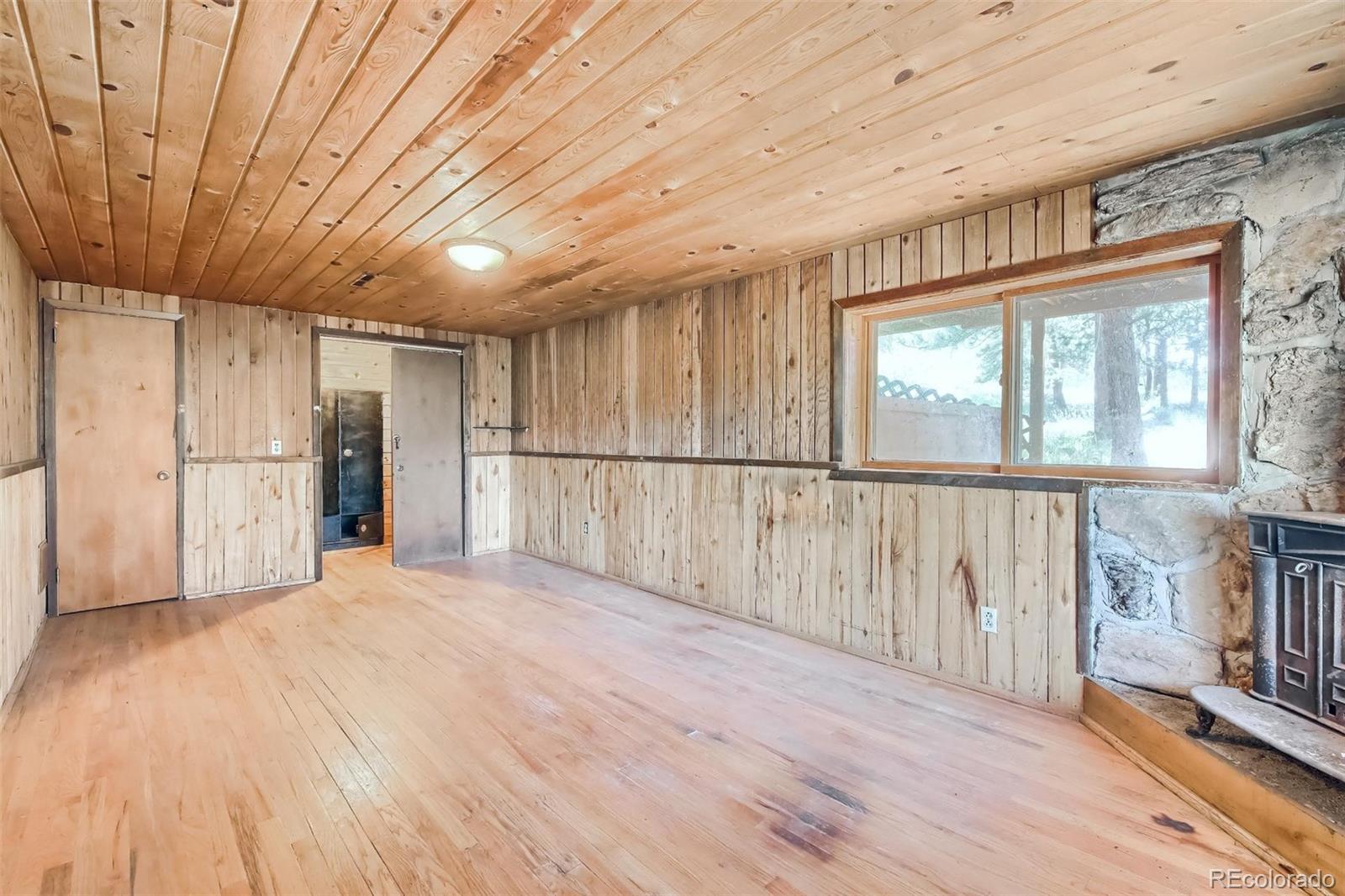 145 Bailey Drive Bailey, CO 80421 - Photo 27 of 40 a view of an empty room with wooden floor and a window