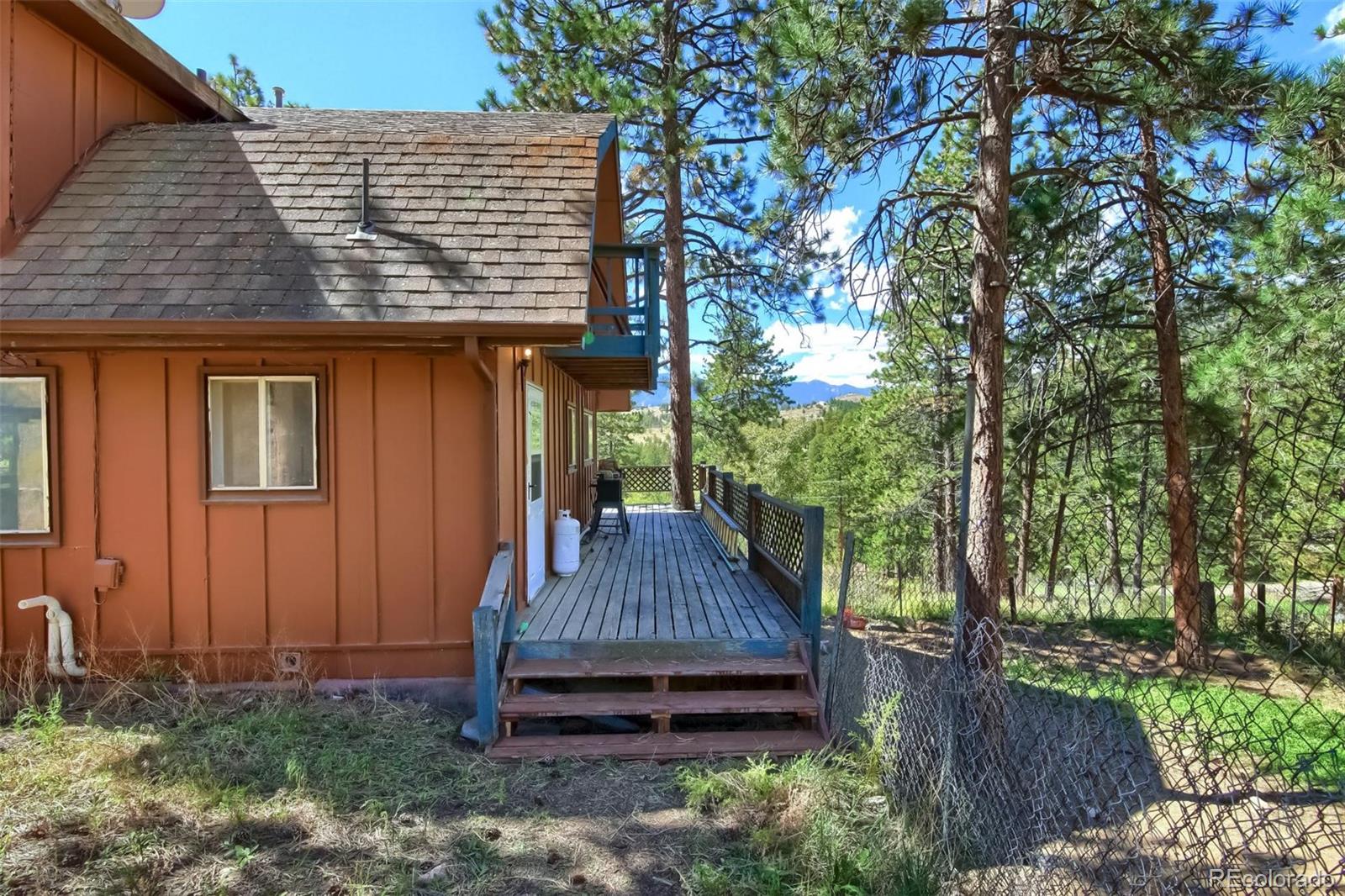 145 Bailey Drive Bailey, CO 80421 - Photo 36 of 40 a view of a house with a yard and wooden fence