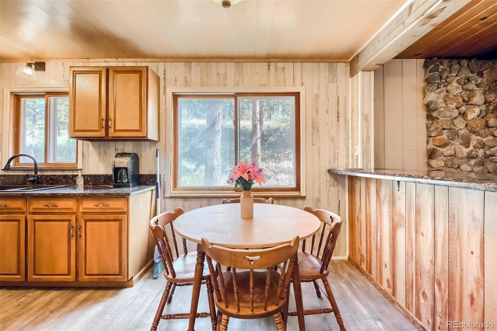145 Bailey Drive Bailey, CO 80421 - Photo 10 of 40 a kitchen with a table chairs sink and cabinets