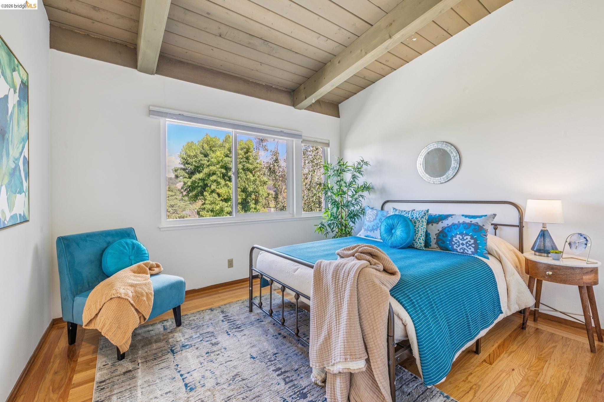 1024 Overlook Road Berkeley, CA 94708 - Photo 33 of 41 Vaulted wood-paneled ceiling with exposed beams, large picture windows, wood-finish flooring, and a contemporary wall mirror
